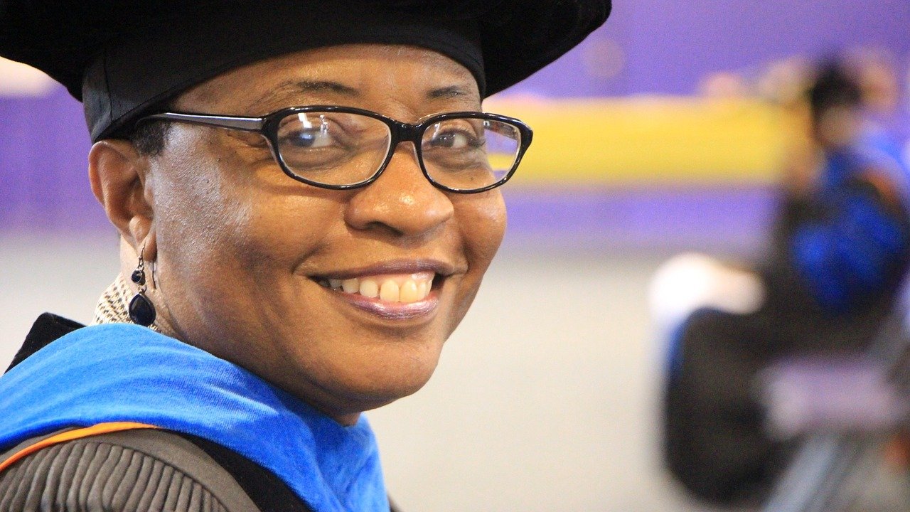A Black, female professor smiles at the camera